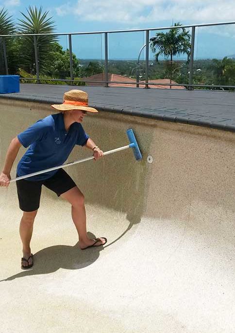 Gretel cleans calcium deposits from pool wall using an acid wash
