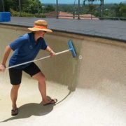 Gretel cleans calcium deposits from pool wall using an acid wash