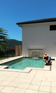 Marcus tests pool water during a regular pool maintenance visit